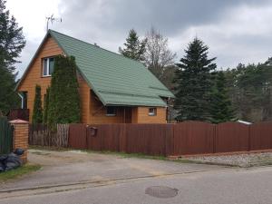 una casa con techo verde y valla en usokoła, en Gawrych Ruda