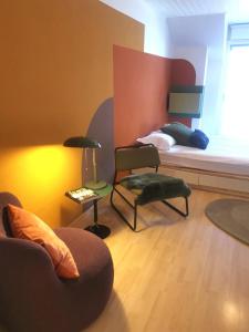 a room with a bed and a couch and a chair at Studios des Arcades in La Neuveville