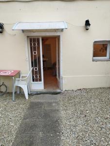 an open door with a table next to a building at Cosy Studio meublé avec piscine partagée in La Ferté-Gaucher