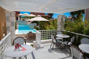 吉雄的住宿－Dimani Suites，一个带桌椅和遮阳伞的庭院
