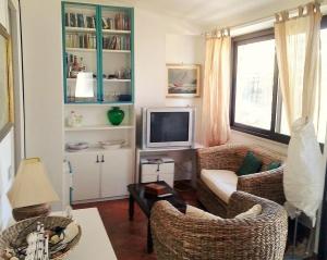 een woonkamer met 2 stoelen en een televisie bij Gaeta Villino Isabella in Gaeta