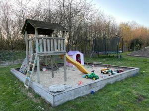 a playground with a slide in a sandbox at Assendrupgaard Vejle in Vejle