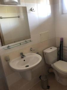 een badkamer met een wastafel, een toilet en een spiegel bij Cute Studio Apt, Pollo Resort in Sunny Beach