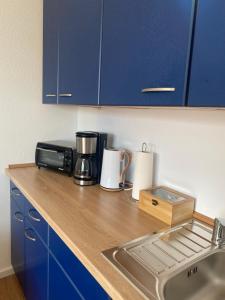 a kitchen counter with a coffee maker and a microwave at Klytti‘s Pension in Sendenhorst
