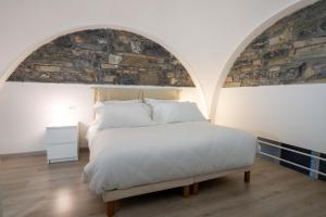 ein Schlafzimmer mit einem großen Bett und einer Steinmauer in der Unterkunft The Secret Garden in Como