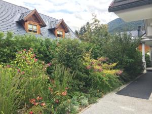 a garden in front of a house with flowers at Apartmaji Kranjska Gora in Kranjska Gora