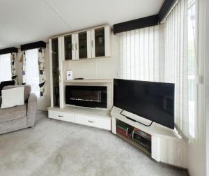 a living room with a large flat screen tv at Meadow Lodge in South Cerney