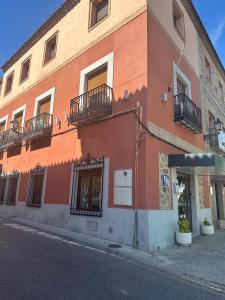 an orange building with balconies on a street at Hostal Toledo Plaza in Toledo