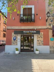 un panneau toledo à l'avant d'un bâtiment dans l'établissement Hostal Toledo Plaza, à Tolède