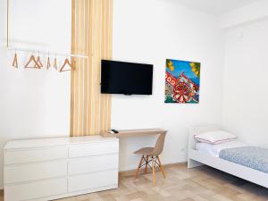 une chambre avec un lit et un bureau avec une télévision dans l'établissement Villa di Nera Apartments, à Palerme