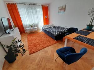 een woonkamer met een bed en een tafel bij Kinga in Toruń