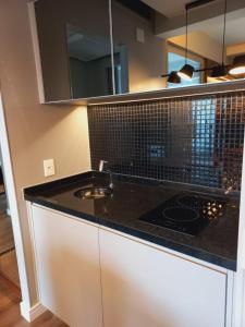 a kitchen with a black counter top and a sink at Estanplaza Berrini in Sao Paulo
