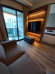 a living room with a couch and a large window at Estanplaza Berrini in Sao Paulo