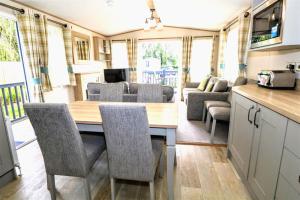 a kitchen and dining area of an rv with a table and chairs at Sunnyside - Willow View in South Cerney