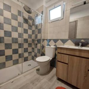 ein Bad mit einem WC, einer Dusche und einem Waschbecken in der Unterkunft piso el puntual 1 in Les Arriondes