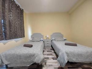 dwa łóżka siedzące obok siebie w pokoju w obiekcie piso el puntual 1 w mieście Arriondas