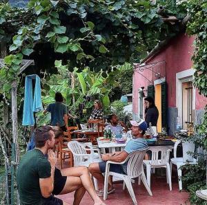 um grupo de homens sentados numa mesa fora de um restaurante em @gatetothewild em Coreglia Ligure