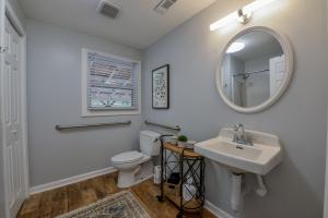 a bathroom with a sink and a toilet and a mirror at Southern Jewel in Tuscaloosa +31 photos