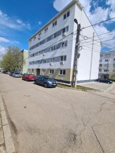a large white building with cars parked in front of it at Garsoniera lux Lorena&Kevin in Piteşti