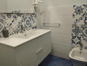 La salle de bains blanche est pourvue d'un lavabo et de toilettes. dans l'établissement Hotel La Giara, à Zambrone