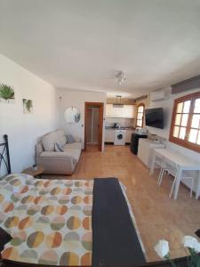 uma sala de estar com um sofá e uma cozinha em Studio Cielo- pool, wi-fi & more em Los Urrutias