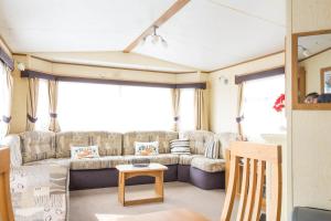 a living room with a couch and a table at 8 Berth Caravan For Hire At California Cliffs Holiday Park In Norfolk Ref 50046l in Great Yarmouth