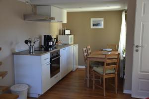 Una pequeña cocina con una mesa y un microondas. en Ferienwohnung Gänsemarkt, en Born 19 fotos más