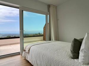 Un dormitorio con una cama y una gran ventana de cristal. en Apartamento Puerta de Comillas - Monabri, en Canales