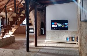 sala de estar con TV en la pared en Galileo Cottage House (BREAKBOOKING CY), en Parekklisha