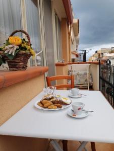 einen weißen Tisch mit zwei Teller Essen drauf. in der Unterkunft Casa ENGY in Terrasini