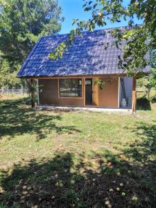 a small house with a solar roof on a yard at Cabaña Bello entorno natural! in Lago Ranco