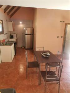 a kitchen with a table and chairs and a refrigerator at Cabaña Bello entorno natural! in Lago Ranco