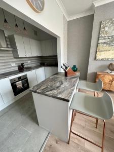 uma cozinha com armários brancos e uma bancada em mármore em Southsea 2 bedroom 10 mins from Beach em Portsmouth