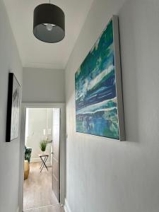 un pasillo con una pintura colgada en la pared en Southsea 2 bedroom 10 mins from Beach en Portsmouth