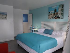 um quarto com uma cama grande e uma parede azul em Snooze em Fort Lauderdale
