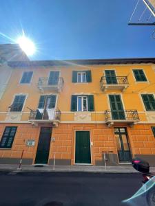 a yellow building with windows and doors on a street at Tropicale in Rapallo