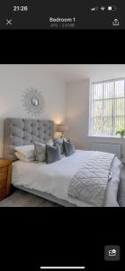 a bedroom with a large white bed with a large window at 97a 97b Captains House in Plymouth