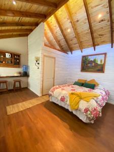 een slaapkamer met een bed in een kamer met houten plafonds bij Loft Cabaña El Recuerdo in Maipo