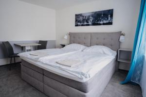 a bedroom with a large bed with white sheets at Penzion Quattro in Ústí nad Orlicí