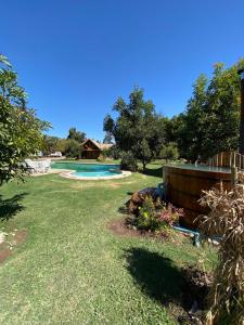 een tuin met een zwembad en een huis bij Loft Cabaña El Recuerdo in Maipo