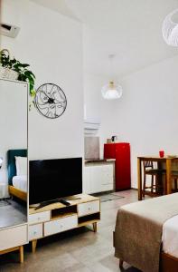 un soggiorno con TV e orologio a muro di Casa Artesano, appartamento San Michele a Trapani