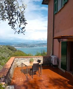 una mesa y sillas en un balcón con vistas al agua en Tenuta di Venere, en Portovenere