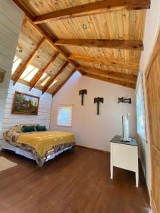 una camera con letto e soffitto in legno di Loft Cabaña El Recuerdo a Maipo