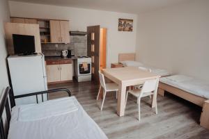 ein kleines Zimmer mit einem Tisch und einem Bett sowie einer Küche in der Unterkunft Penzion Quattro in Ústí nad Orlicí