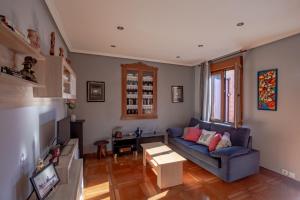uma sala de estar com um sofá azul e uma mesa em Casa Rural La Sosiega con jardín privado em Bernueces