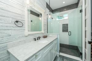 un bagno bianco con lavandino e doccia di Dry Dock a Siesta Key