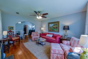 a living room with red furniture and a ceiling fan at Bama Bungalow in Tuscaloosa