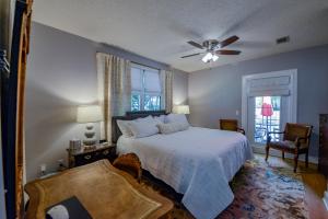 Un dormitorio con una cama y un ventilador de techo. en Bama Bungalow, en Tuscaloosa