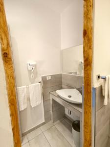 a white bathroom with a sink and a mirror at Tenuta di Venere in Portovenere