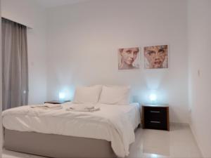 ein Schlafzimmer mit einem Bett mit zwei Bildern an der Wand in der Unterkunft Zelea Deluxe Apartment (BREAKBOOKING CY) in Limassol